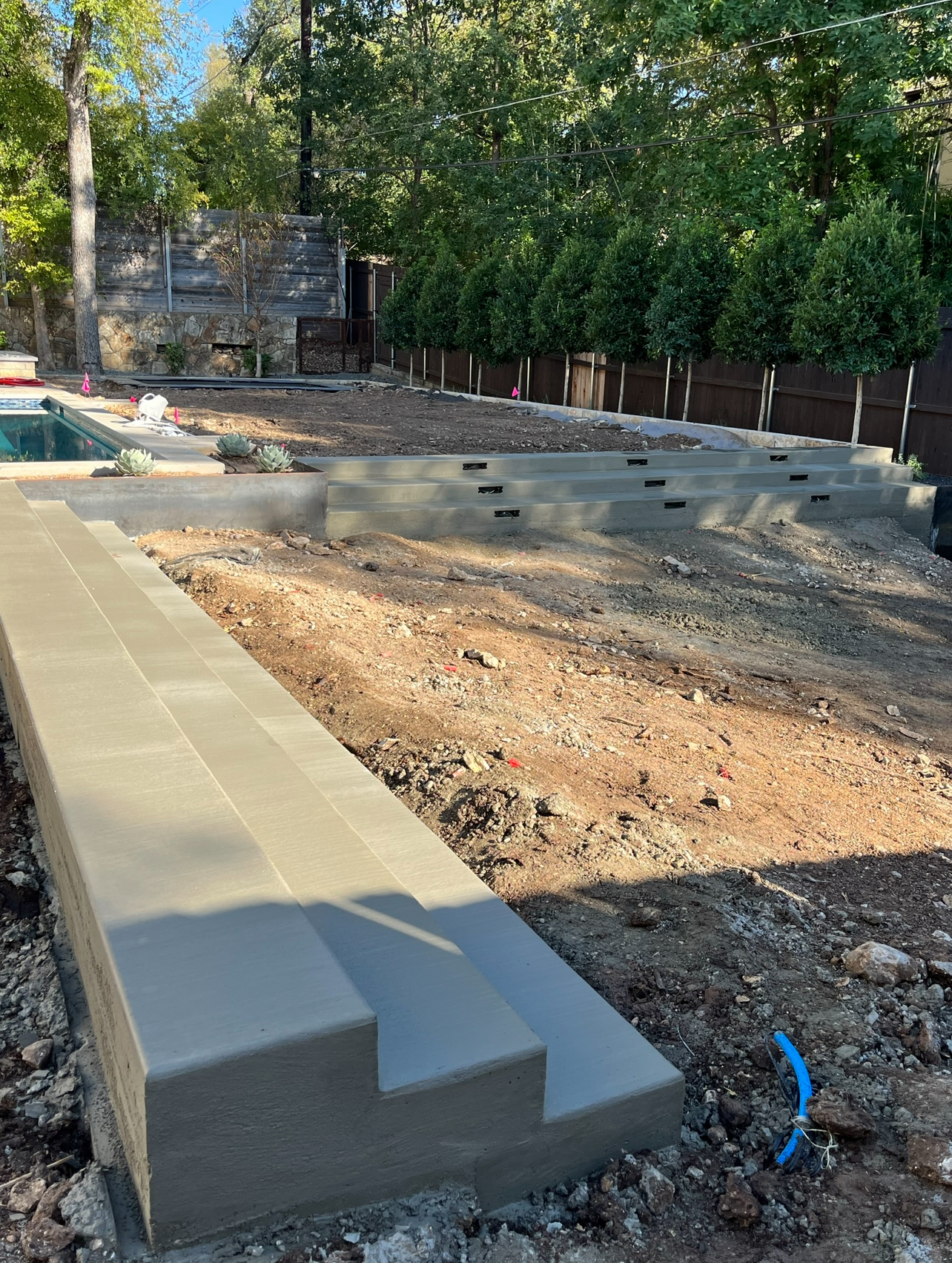 Custom poured concrete backyard steps and walkway leading to pool with smooth modern finish